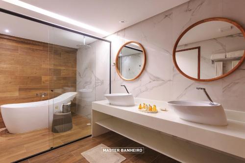 a bathroom with two sinks and a large mirror at Armação Resort Porto de Galinhas in Porto De Galinhas