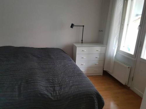 a bedroom with a bed and a dresser and a window at Apartment with sauna near the center in Helsinki