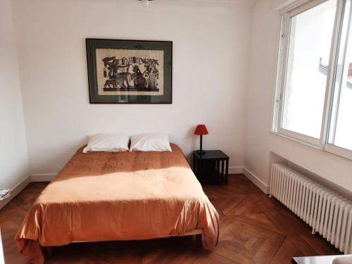 a bedroom with a bed and a picture on the wall at Loue maison 10 couchages à La Rochelle avec jardin, proche plage in La Rochelle