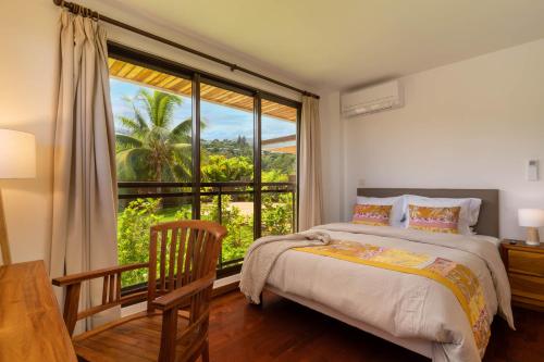 1 dormitorio con cama y ventana grande en Magnificent 5 Br Villa with pool: amazing views, en Punaauia