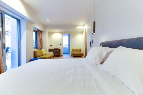 a bedroom with a large white bed and two chairs at AboV Athens in Athens