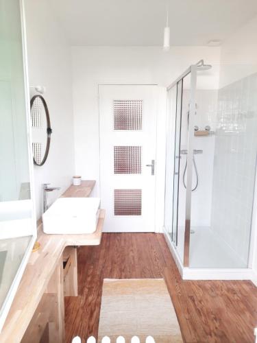 une salle de bain blanche avec un lavabo et une douche dans l'établissement Loue maison 10 couchages à La Rochelle avec jardin, proche plage, à La Rochelle