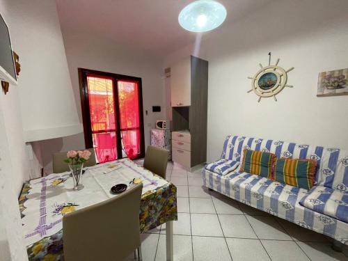- un salon avec une table et un canapé dans l'établissement Residenza ICHNUSA, à Villasimius