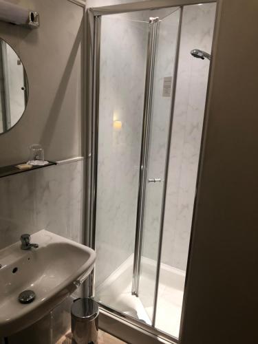 a bathroom with a shower and a sink at Burton Lodge Guest House & Spa in Brandesburton