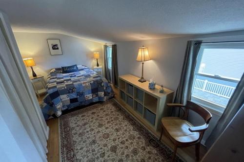 una camera da letto con un letto, una sedia e una finestra di Waterfront Cottage and Ski Getaway! a Sunapee