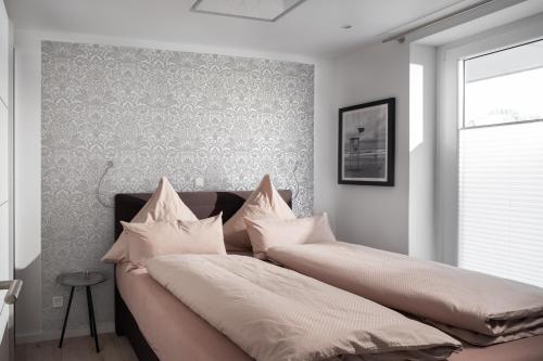 ein Schlafzimmer mit einem Bett mit Kissen darauf in der Unterkunft Ferienwohnung Krabbe in Wangerooge
