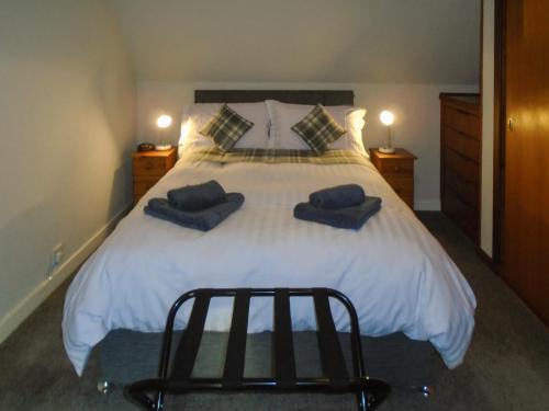 a bedroom with a large white bed with two blue pillows at Oyster Catcher in Embo