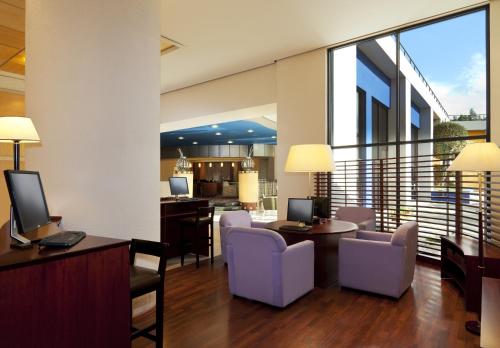 a living room with chairs and tables and a balcony at Mak Albania Hotel in Tirana