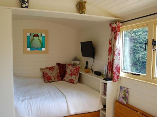 a small bedroom with a bed and a window at Hicks Hut -ukc4753 in Tremeirchion