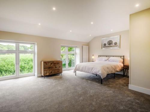 a bedroom with a large bed and windows at The Gallery Barn - Uk39368 in Swafield