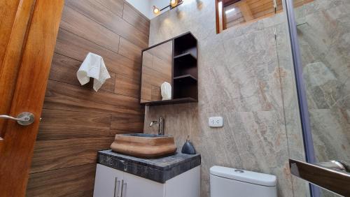 y baño con lavabo de madera y aseo. en Huandoy Lodge - Huaraz, en Yungay