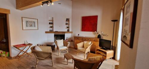 a living room with a table and chairs and a television at Les Majis 20 in Champoussin