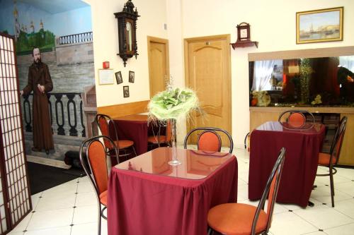 uma sala de jantar com duas mesas com toalha de mesa vermelha em Dom Dostoevskogo em São Petersburgo