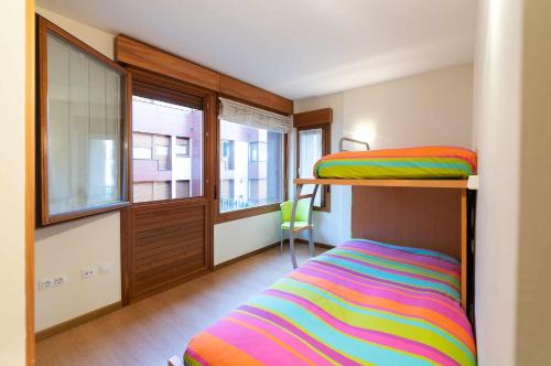 a bedroom with a bunk bed with a colorful striped blanket at Apartamento Mirador Playa de Barro in Barro de Llanes