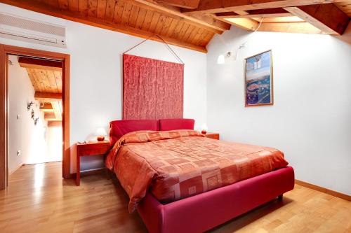 ヴェネツィアにあるLittle Canal 14の赤いベッドと赤いオットマンが備わるベッドルーム1室