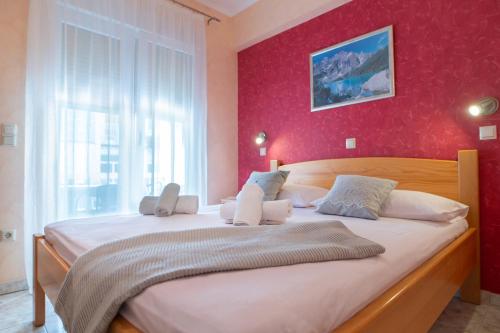ein Schlafzimmer mit einem großen Bett mit einer roten Wand in der Unterkunft Villa Sladojević in Omiš