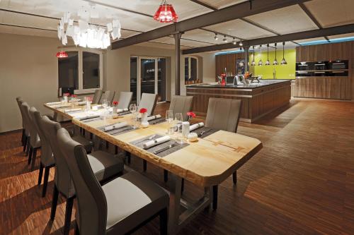 a large dining room with a long table and chairs at Hotel An der Wasserburg in Wolfsburg