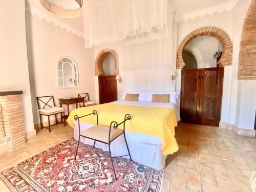 ein Schlafzimmer mit einem gelben Bett und einem Teppich in der Unterkunft El Rincón de las Descalzas in Carmona