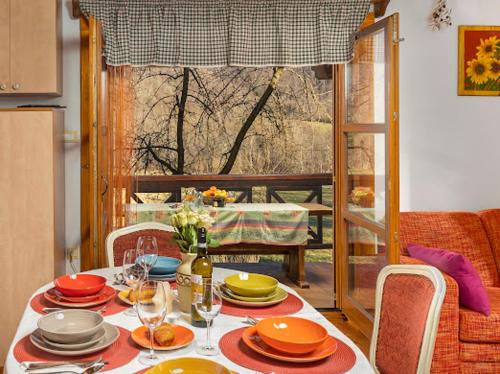 a dining room table with plates and wine glasses at Holiday House Sofia in Delnice