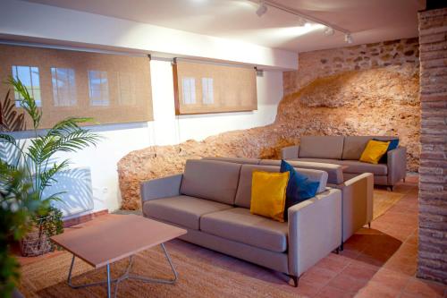 TorrellesにあるCasa Rural Hospital de las Palabrasの石壁のリビングルーム(ソファ2台付)