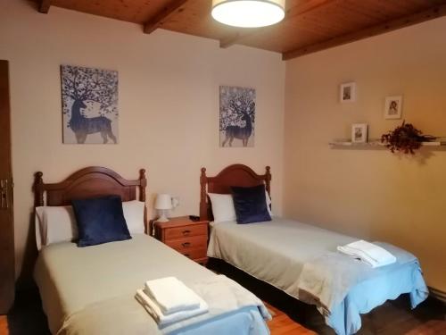 a bedroom with two beds with blue pillows at Casa Licerio in Samos