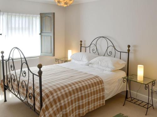a bedroom with a large bed and two tables at Trelawny Court in Saint Minver