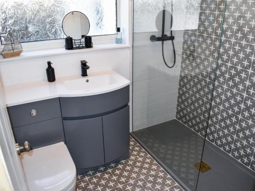 ein Bad mit einem Waschbecken und einer Dusche in der Unterkunft Gull House in Dungeness
