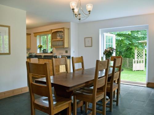 a kitchen and dining room with a wooden table and chairs at Cornant in Llechryd
