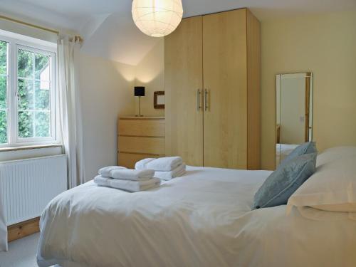 a bedroom with a white bed with towels on it at Cornant in Llechryd