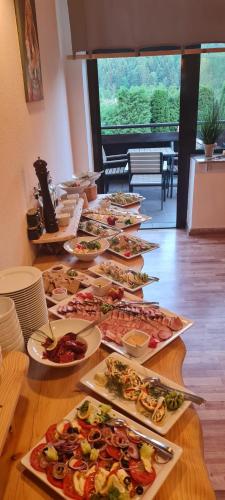 a long table with many plates of food on it at Perełka Bieszczady Domki in Cisna