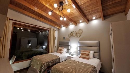 a bedroom with two beds and a mirror at Huandoy Lodge - Huaraz in Yungay