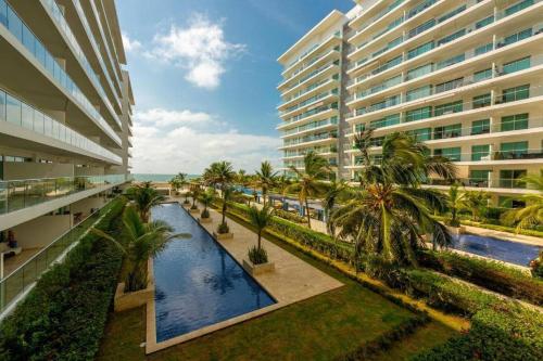 un complejo de apartamentos con piscina y palmeras en Apartamento en Condominio con Salida al Mar MORROS EPIC, en Cartagena de Indias