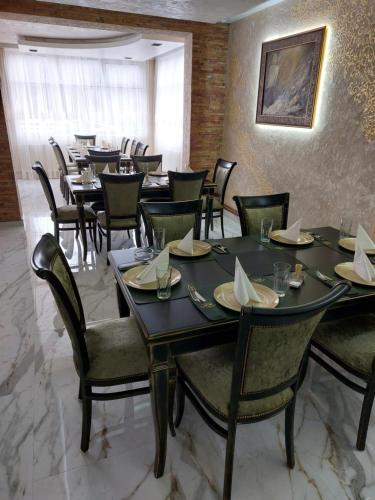 ein Restaurant mit Tischen und Stühlen in einem Zimmer in der Unterkunft JOKSIM Rooms&Restaurant in Kuršumlija