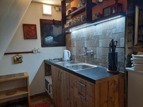 a kitchen with a sink and a stone wall at Snow Angel Jahorina in Jahorina