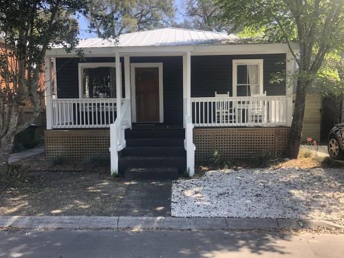 a small house with a white porch and stairs at Chic Retreat in Downtown St Augustine in St. Augustine