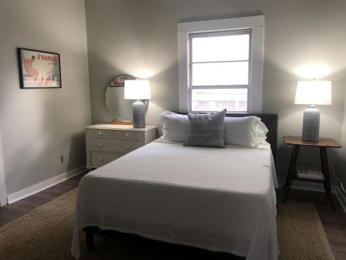 - une chambre avec un lit, deux lampes et une fenêtre dans l'établissement Chic Retreat in Downtown St Augustine, à Saint Augustine