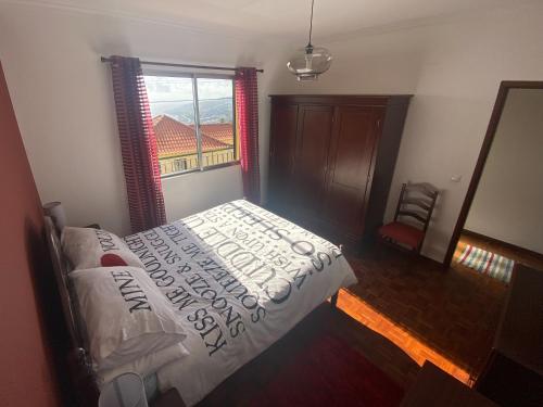 a bedroom with a bed and a large window at Casa Madeira in Santa Cruz
