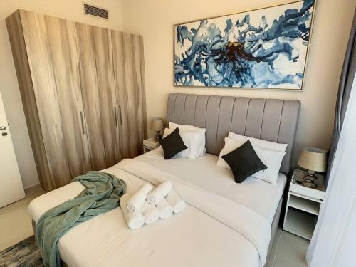 a bedroom with a bed with white sheets and pillows at Key View - Golf Vita in Dubai Marina