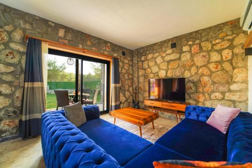 sala de estar con sofá azul y TV en Villa Diamond fethiye, en Fethiye