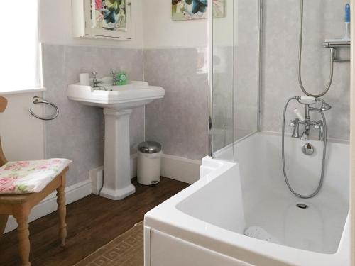 een badkamer met een wastafel, een bad en een douche bij Ash Cottage in Tideswell