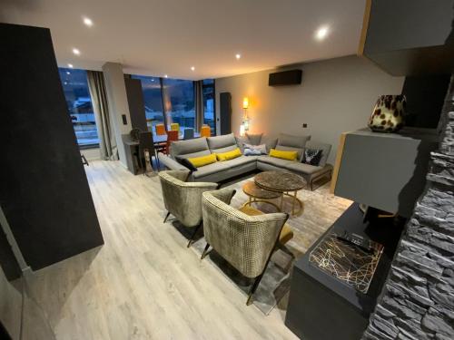 un salon avec un canapé et des chaises dans l'établissement AU JARDIN DU CLOS, à Brides-les-Bains