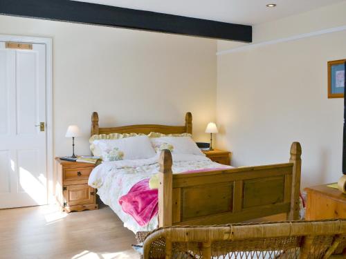 a bedroom with a bed and two night stands and two lamps at Glendale Mews in Haltwhistle