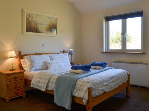 a bedroom with a bed with blue stuffed animals on it at Wellys Wallow in Saint Kew