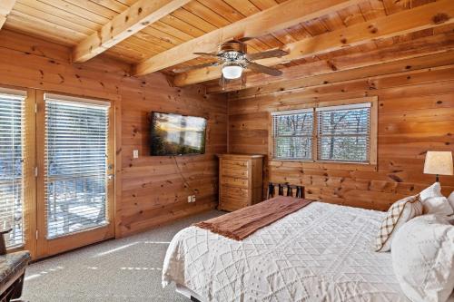 a bedroom with a bed and a ceiling fan at SunnySierra Cabin in Sevierville