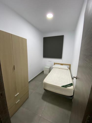 - une chambre avec un lit et une télévision à écran plat dans l'établissement APARTAMENTOS PASCUAL, à El Cuervo