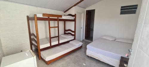 a small room with two bunk beds in it at Chalé Beija Flor in Praia do Frances