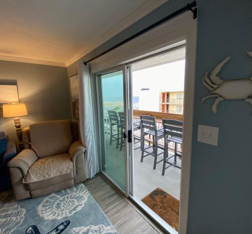 a living room with a sliding glass door with a view of the ocean at Marylander Condominiums, 90 steps from the beach in Ocean City