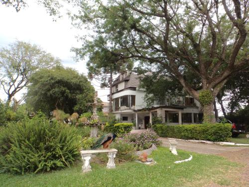 a statue of a woman sitting on a bench in front of a house at ROSA CORTIANA Escalera in São Gabriel