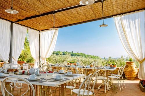 a dining room with tables and chairs on a patio at Villa Bonazza in Marcialla