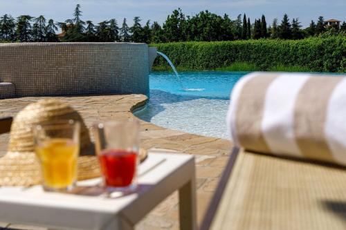 two drinks on a table next to a swimming pool at Villa Bonazza in Marcialla